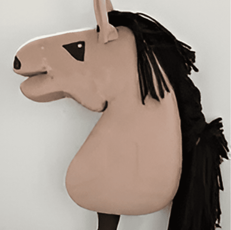 A plush horse mask with black mane, beige face, and black triangle detail around the eye, displayed against a plain background.